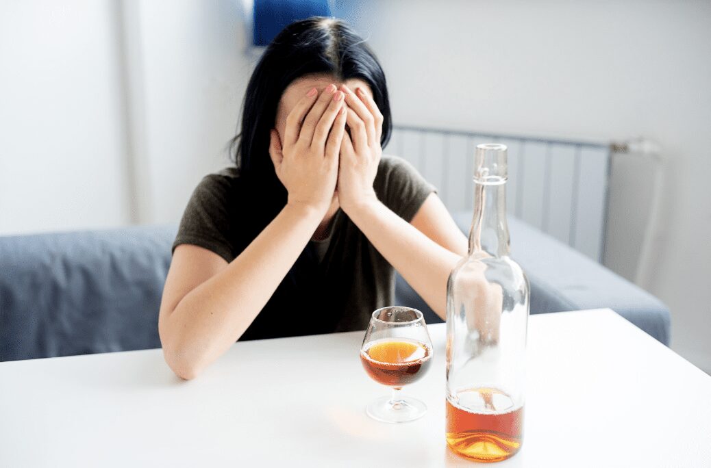 A person sitting in front of alcohol.