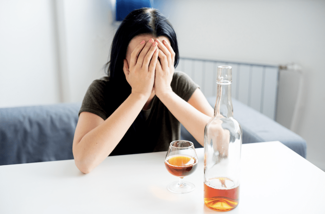 A person sitting in front of alcohol.
