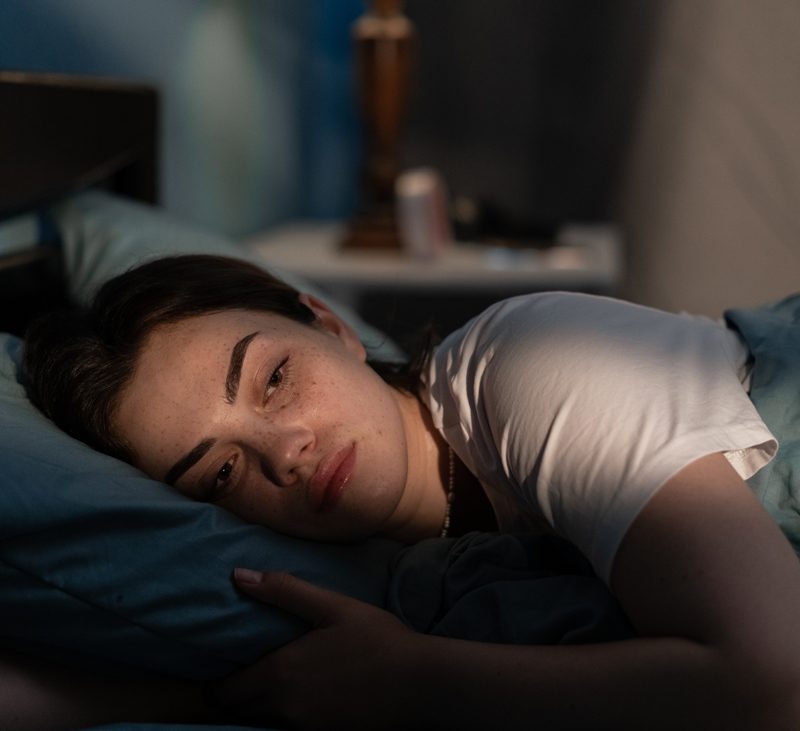woman laying in bed at night awake with anxiety