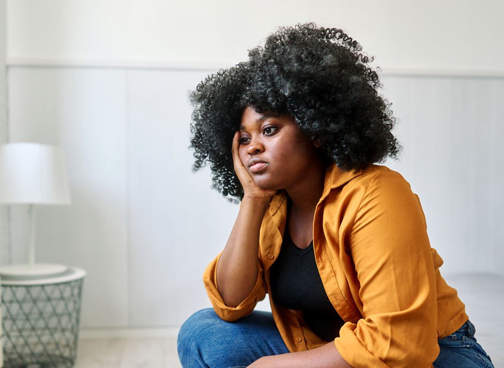 sad woman sitting with her head in her hands